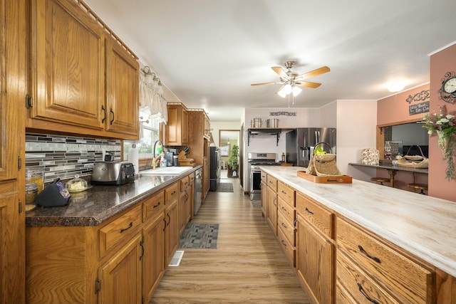 940 Industrial Dr, Neosho, MO 64850 - kitchen with a sink, stainless steel appliances, ceiling fan, brown cabinetry, and light wood-type flooring