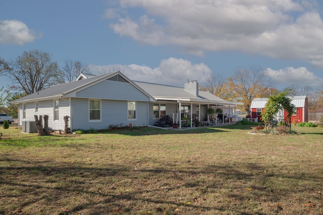 940 Industrial Dr, Neosho, MO 64850 - rear view of house featuring metal roof, a chimney, central AC, and a lawn