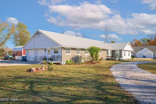 940 Industrial Dr, Neosho, MO 64850 - ranch-style house featuring driveway, a front lawn, a garage, and metal roof