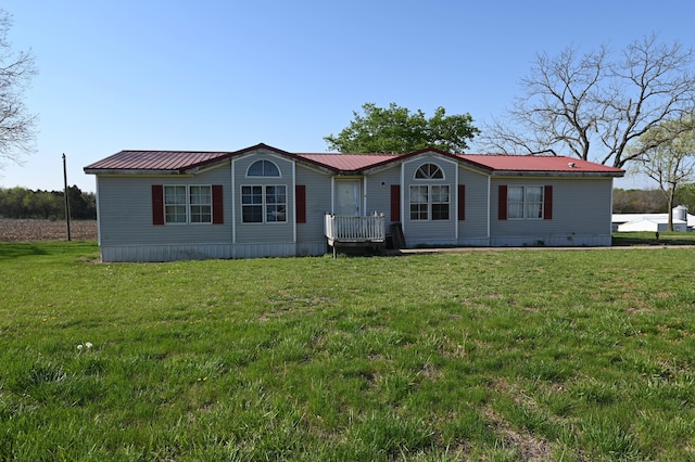 manufactured / mobile home featuring a front yard and metal roof