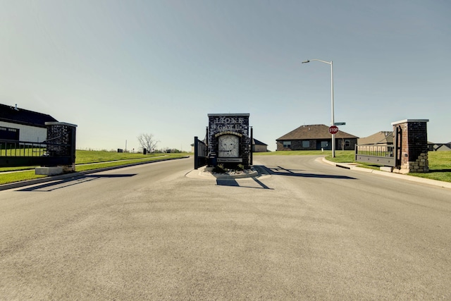 5896 Applewood Ave, Springfield, MO 65810 - view of street with sidewalks, a gated entry, traffic signs, street lighting, and curbs