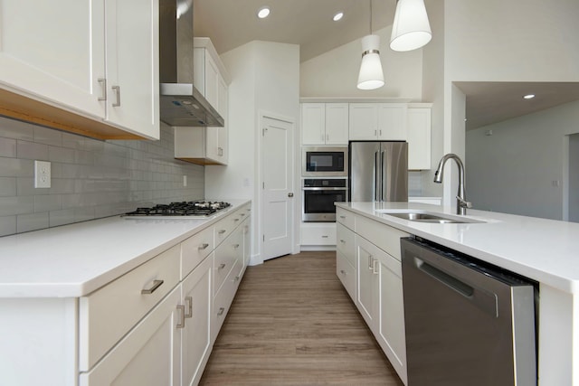 5896 Applewood Ave, Springfield, MO 65810 - kitchen featuring white cabinets, a sink, light wood-style floors, wall chimney exhaust hood, and appliances with stainless steel finishes