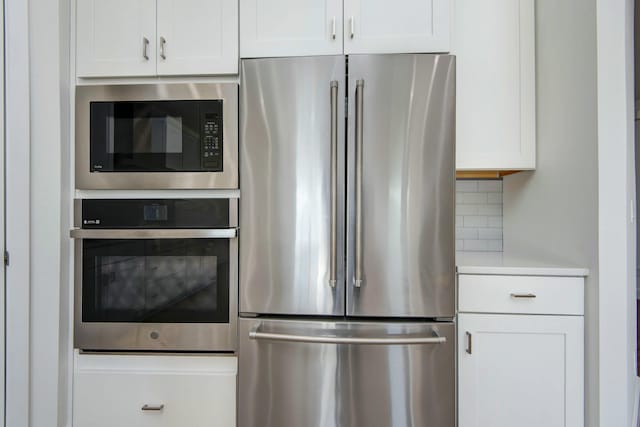 5896 Applewood Ave, Springfield, MO 65810 - kitchen featuring light countertops, white cabinetry, decorative backsplash, and stainless steel appliances