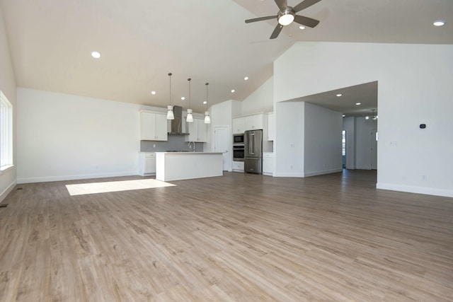 5896 Applewood Ave, Springfield, MO 65810 - unfurnished living room with baseboards, a ceiling fan, high vaulted ceiling, and light wood-style flooring