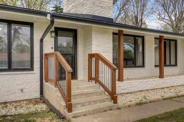 704 King St, Mount Vernon, MO 65712 - view of exterior entry with a chimney, brick siding, and stone siding