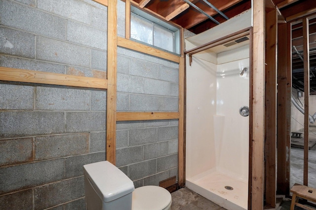 704 King St, Mount Vernon, MO 65712 - bathroom with toilet, visible vents, concrete block wall, and a stall shower