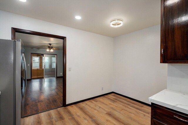 704 King St, Mount Vernon, MO 65712 - kitchen featuring light wood-style flooring, ceiling fan, dark brown cabinetry, baseboards, and stainless steel refrigerator with ice dispenser