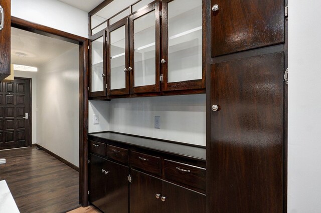 704 King St, Mount Vernon, MO 65712 - kitchen with dark brown cabinets, glass insert cabinets, baseboards, and dark wood-style flooring