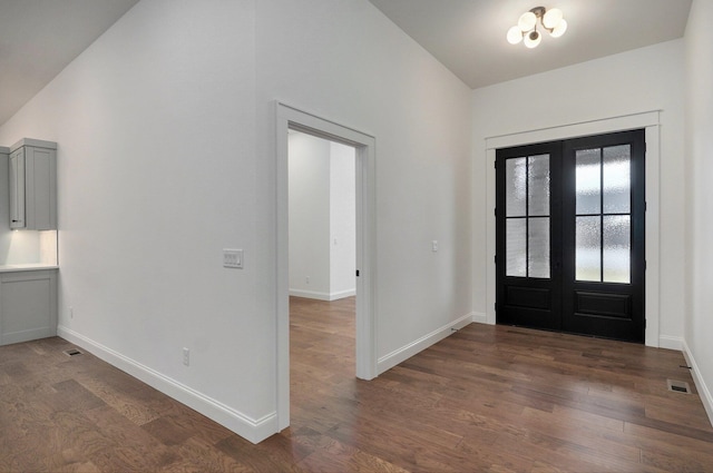 foyer featuring lofted ceiling, french doors, dark wood-type flooring, and baseboards
