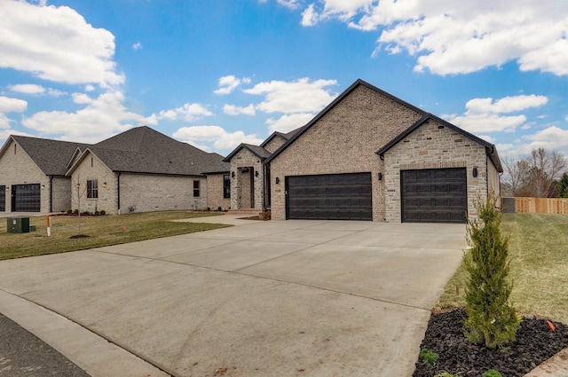 view of front facade featuring an attached garage, driveway, brick siding, and a front yard