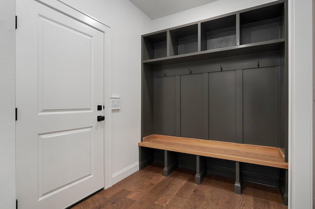 mudroom featuring baseboards and dark wood-type flooring