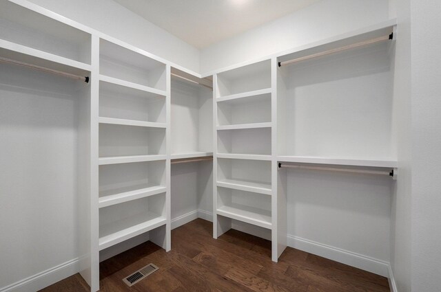 spacious closet with dark wood finished floors and visible vents