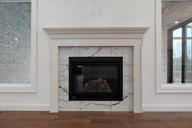 interior details featuring a premium fireplace, wood finished floors, and baseboards