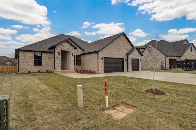 french country home featuring concrete driveway, a front lawn, fence, a garage, and brick siding