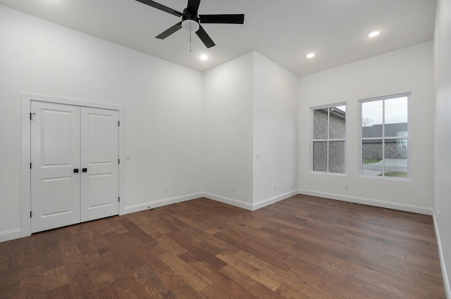 unfurnished room with baseboards, a ceiling fan, dark wood-type flooring, and recessed lighting