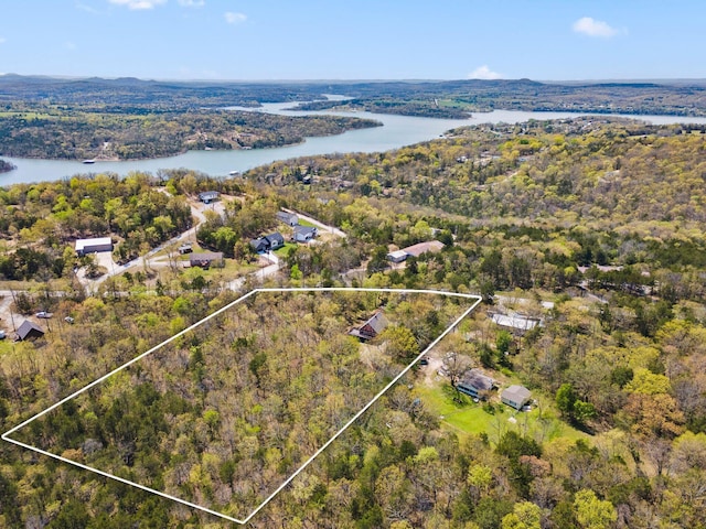 drone / aerial view with a forest view and a water view