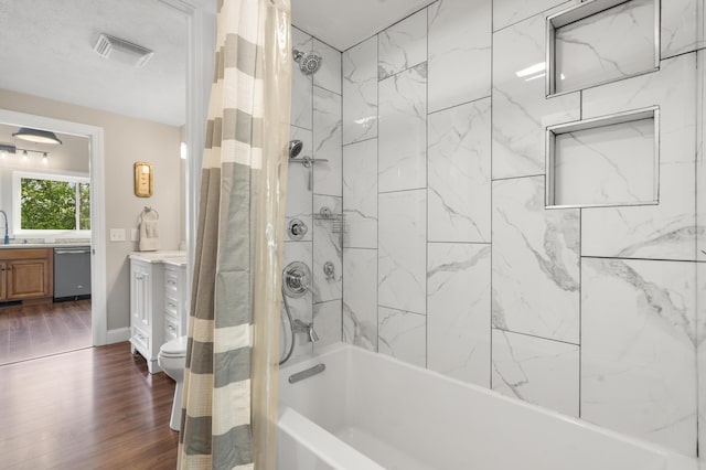 bathroom with shower / bath combo with shower curtain, vanity, wood finished floors, and visible vents