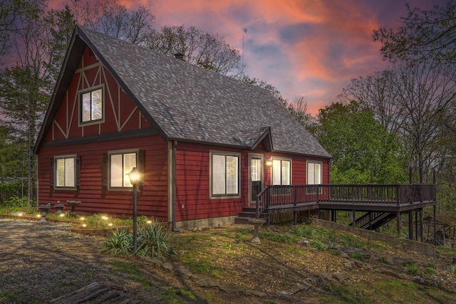 exterior space featuring a wooden deck, a shingled roof, and stairway