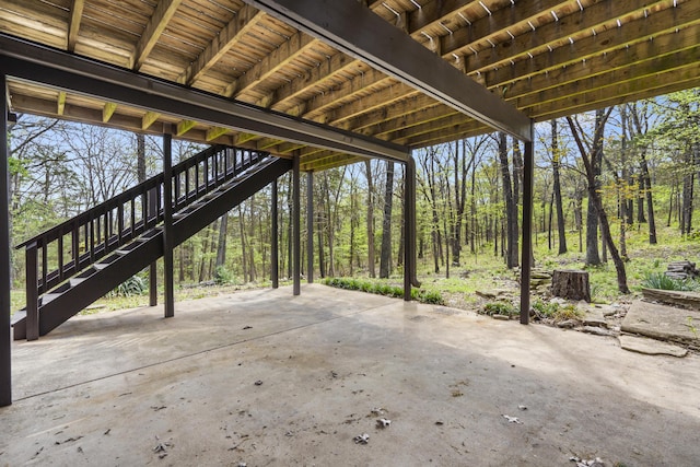 view of patio / terrace with a view of trees and stairs