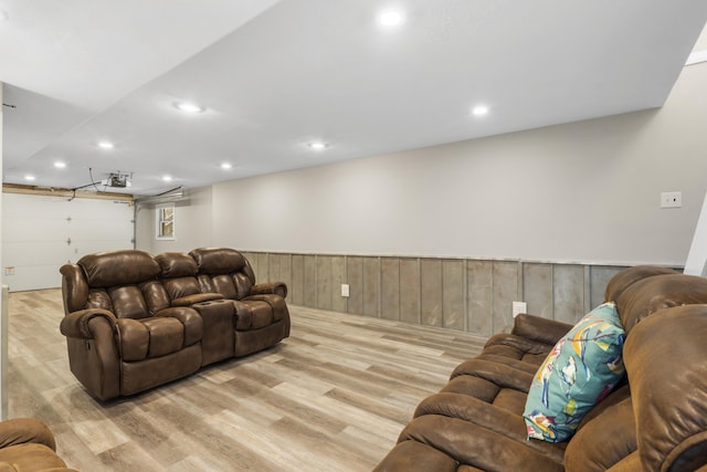 living room with wood walls, wood finished floors, and recessed lighting