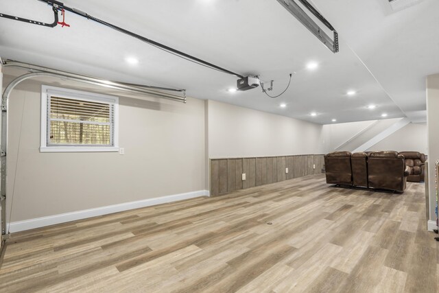 basement featuring baseboards, recessed lighting, wood finished floors, and a garage