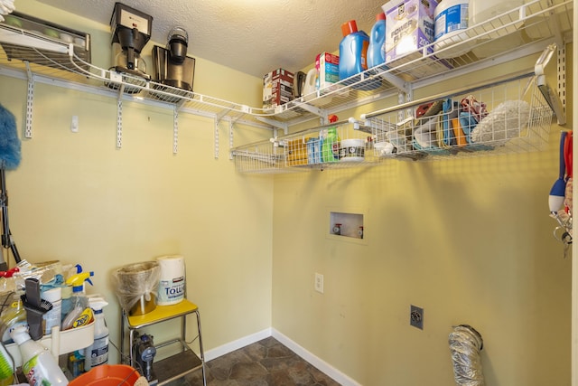 clothes washing area with hookup for an electric dryer, baseboards, washer hookup, stone finish floor, and laundry area