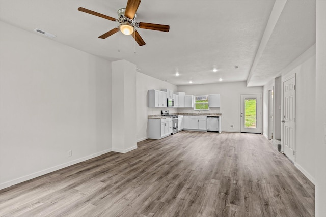 510 N Henry St, Mansfield, MO 65704 - unfurnished living room featuring baseboards, a ceiling fan, wood finished floors, and visible vents