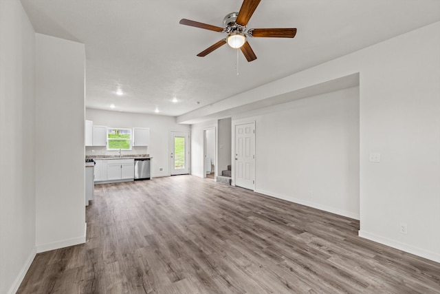 510 N Henry St, Mansfield, MO 65704 - unfurnished living room featuring ceiling fan, baseboards, wood finished floors, and a sink