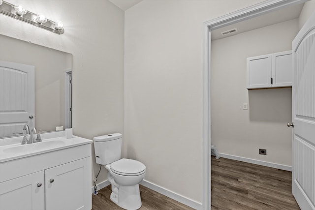510 N Henry St, Mansfield, MO 65704 - bathroom with toilet, baseboards, visible vents, wood finished floors, and vanity