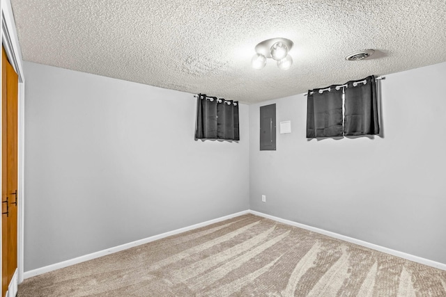 unfurnished room with carpet, a textured ceiling, and electric panel