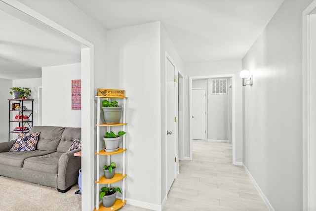 hallway featuring baseboards and light wood-style floors