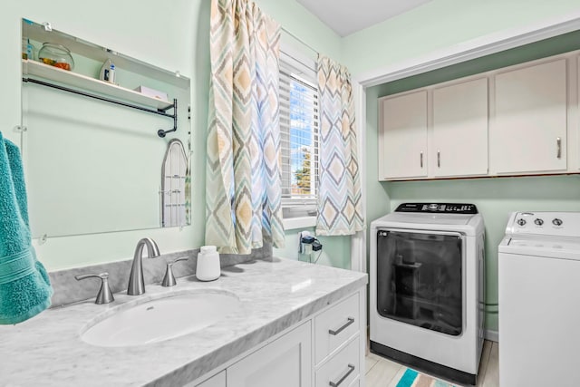 laundry area featuring washing machine and dryer and a sink