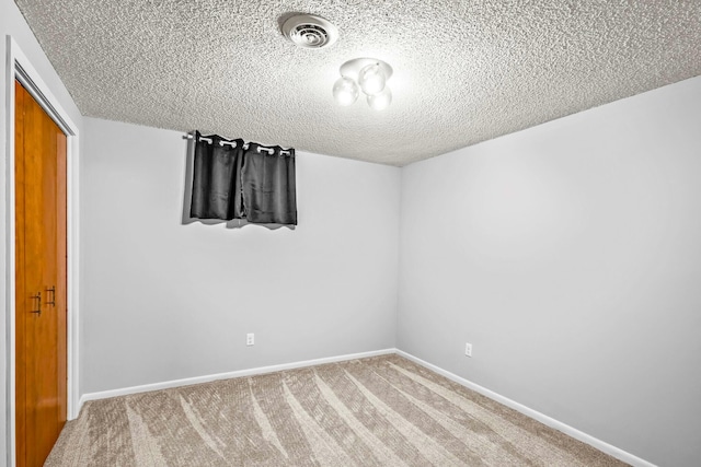 unfurnished bedroom featuring a textured ceiling, visible vents, carpet, and a closet