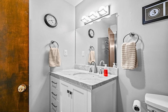 half bath featuring vanity and toilet