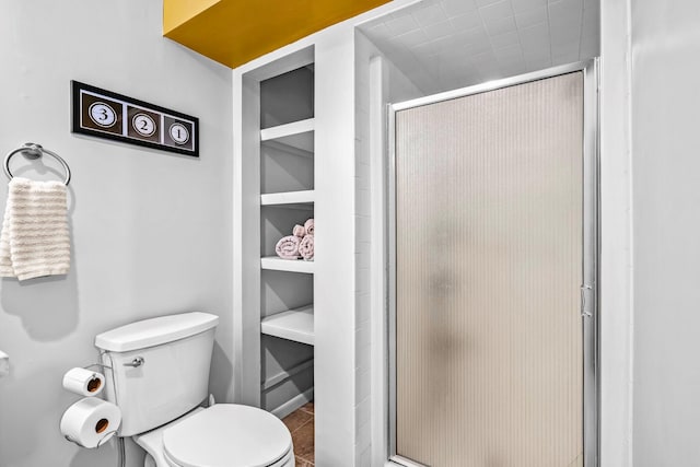full bath featuring toilet, tile patterned floors, and a stall shower