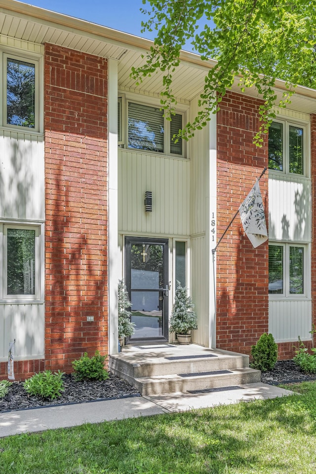 entrance to property featuring brick siding