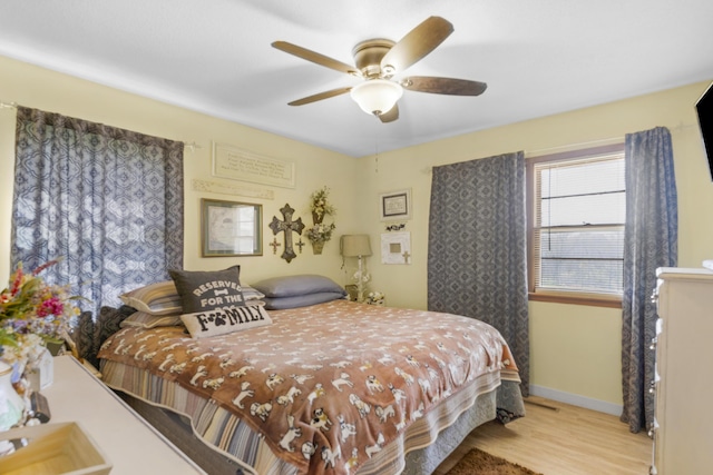 bedroom featuring baseboards, a ceiling fan, and wood finished floors