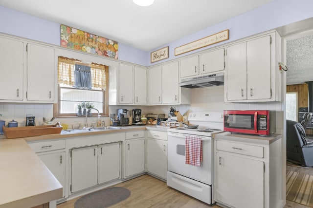 kitchen featuring under cabinet range hood, a healthy amount of sunlight, white electric stove, and a sink