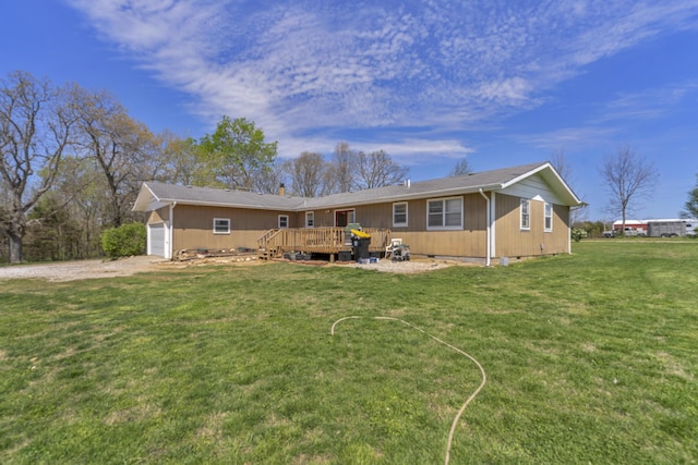 back of house featuring a wooden deck, a yard, and driveway