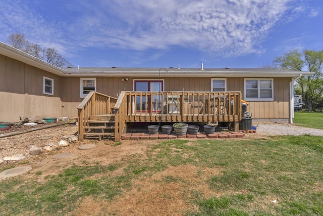 rear view of house featuring a yard and a deck