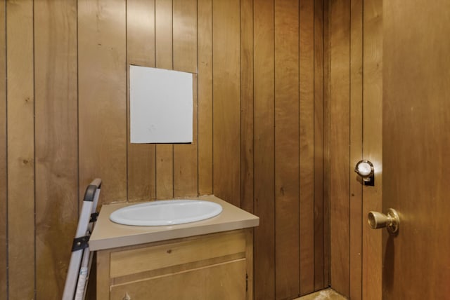 bathroom featuring wooden walls and vanity