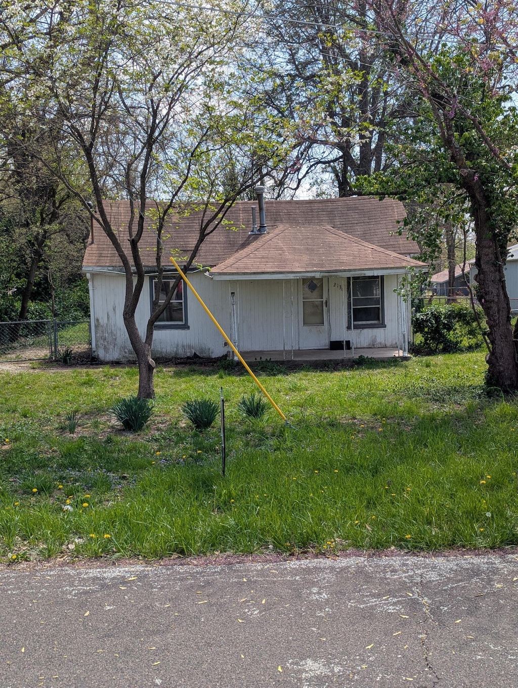 ranch-style home featuring a front lawn and fence