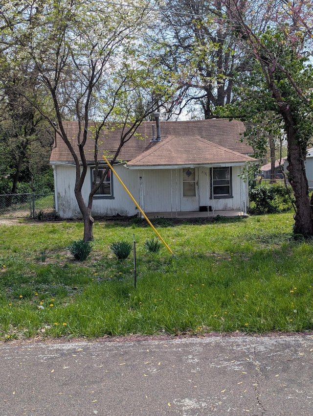 ranch-style home featuring a front lawn and fence