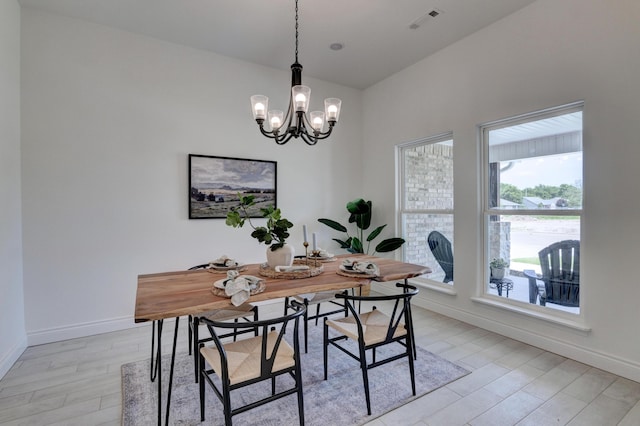 dining area featuring a wealth of natural light, baseboards, visible vents, and an inviting chandelier