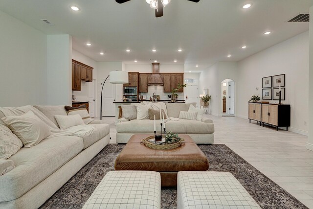 living area with arched walkways, baseboards, ceiling fan, and recessed lighting