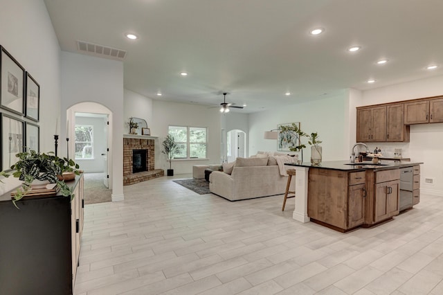 kitchen with dark countertops, visible vents, open floor plan, and a sink