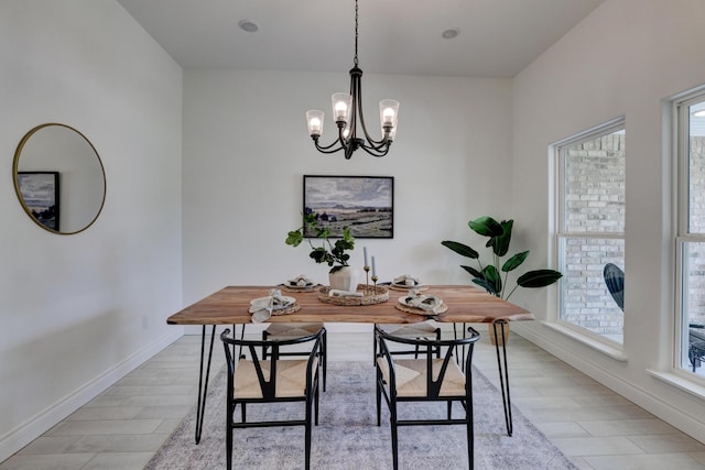 dining space with baseboards, an inviting chandelier, and plenty of natural light