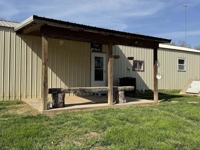 rear view of property with a lawn and metal roof