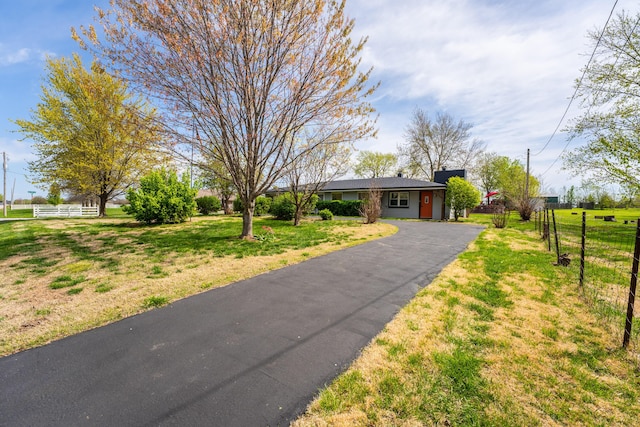 single story home with a front lawn, fence, and aphalt driveway