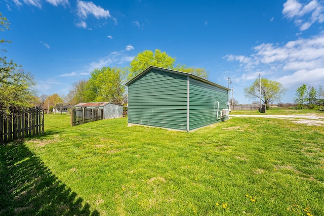 view of outdoor structure featuring fence and an outbuilding